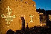 Das Ksar Tissergate mit Lehmmauern und Türmen, befestigtes Dorf mit Berber Zeichen auf Lehmmauer, Draa Tal südlich vom Hohen Atlas, Marokko