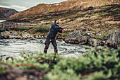 Mann angelt in der Natur Grönlands, Grönland, Arktis.