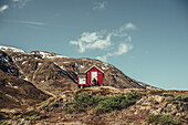 Wanderer vor einer roten Hütte in Grönland, Grönland, Arktis.