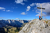 Frau beim Wandern steht am Gipfel des Sonnjoch und blickt auf Karwendelkette, Sonnjoch, Karwendel, Naturpark Karwendel, Tirol, Österreich
