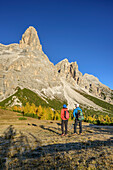 Man and woman hiking looking towards Monte Pelmo, Monte Pelmo, Dolomites, UNESCO World Heritage Site Dolomites, Venetia, Italy