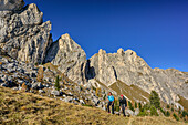 Man and woman hiking ascending towards Col di Lana, Col di Lana, Dolomites, UNESCO World Heritage Site Dolomites, Venetia, Italy