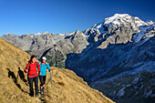 Man and woman hiking with Ortler in background, Stilfser Joch, Ortler group, South Tyrol, Italy