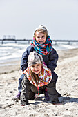 Kinder spielen am Strand im Winter an der Ostsee, Kellenhusen, Schleswig Holstein, Deutschland