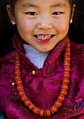 Tibetan child girl with a huge necklace, Tongren County, Rebkong, China.