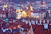 Prague - elevated view of spires of the old town and charles bridge at dusk.