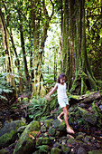 FRENCH POLYNESIA, Moorea. Fiona hiking along a path.