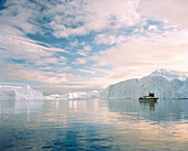 GREENLAND, Ilulissat, Ilulissat Icefjord, a tour boat during a midnight tour of the glaciers with glaciers in the background