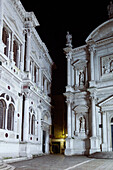 ITALY, Venice. A partial night view of the facades of the Scuola Grande di San Rocco, art museum, on the left and the Chiesa San Rocco on the right.
