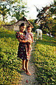BELIZE, Punta Gorda, Toledo District, Nilsa Col holds her sister Wendy in front of their hom in the Maya village of San Jose