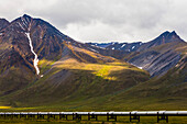 The Trans-Alaska Pipeline crosses over tundra beneath the mountains of the Brooks Range along the Dalton Highway; Alaska, United States of America