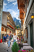 Tourists strolling along busy town square; Courmayeur, Aosta Valley, Italy