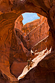Adventure athlete in the womb of a giant slot canyon bowl; Hanksville, Utah, United States of America
