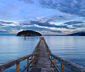 A wooden pier leading out into Bennet Bay in the Gulf Islands at sunset; Mayne Island, British Columbia, Canada