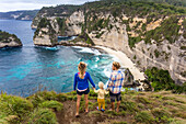 Family on vacations looking at view of coastline with cliffs, Nusa Penida, Bali, Indonesia