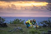 Two boys playing with tent bag at sunset, Nusa Penida, Bali, Indonesia