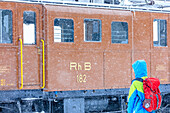 Man looks the snowplow of Bernina Express train, Ospizio Bernina, Poschiavo, canton of Graubünden, Engadin Valley, Switzerland