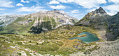 Panoramic of turquoise lake and rocky peaks, Crap Alv Lejets, Albula Pass, canton of Graubünden, Switzerland