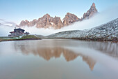 Dolomites Alps, Pale di San Martino reflecting on water with clouds, Baita Segantini, Trentino Alto Adige District, Italy