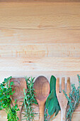 Wooden cooking utensils among aromatic herbs: parsley, sage, thyme, rosemary, Lombardy, Italy