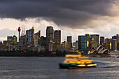 A ferry in Sydney Harbour at dusk with the Opera House and city skyline, Sydney, New South Wales, Australia, Pacific