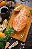 Raw salmon on cutting board with ingredients