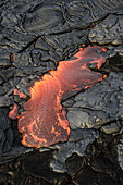 Molten lava glowing near dried lava