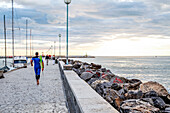 Surfer on the Pier in Viareggio at the Sunset, Viareggio, Tuscany, Italy, Europe