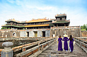 Women in traditional Ao Dai dresses with a paper parasol in the Forbidden Purple City of Hue, UNESCO World Heritage Site, Thua Thien Hue, Vietnam, Indochina, Southeast Asia, Asia