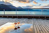 Glowing cognac (brandy) reflections, glass table at sunset, cruise ship stern, Resurrection Bay, Kenai Peninsula, Alaska, United States of America, North America