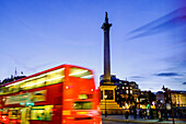 Red bus passing Nelson's Column in Trafalgar Square, London, England, United Kingdom, Europe