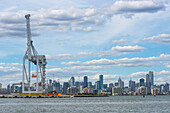 Container quayside crane in the Port of Melbourne with city skyline, Melbourne, Victoria, Australia, Pacific