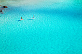 People paddleboarding on the emerald waters of Cala Mitjana, Menorca, Balearic Islands, Spain, Mediterranean, Europe