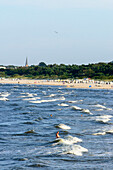 Menschen baden mit hohen Wellen am Strand von Ahlbeck, Usedom, Ostseeküste, Mecklenburg-Vorpommern, Deutschland