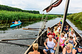Tourists row in a historic wooden boat in the open-air museum Ukranenland in Torgelow, Baltic Sea coast, Mecklenburg-Vorpommern, Germany