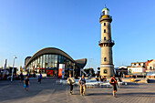 Menschen vor Warnemünde Teepott und Leuchtturm, Ostseeküste, Mecklenburg-Vorpommern, Deutschland