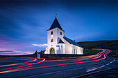 Lights of car trails at church of Eidi at dusk, Eysturoy Island, Faroe Islands, Denmark, Europe