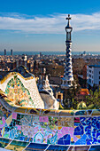 Park Guell houses and mosaic tiles at Parc Guell by Antoni Gaudi, UNESCO World Heritage Site, with views over the city to the sea, Barcelona, Catalonia, Spain, Europe