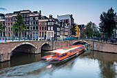 A boat going under a bridge over the Keizersgracht Canal, Amsterdam, Netherlands, Europe