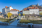 View of buildings along Ljubljanica River and Castle visible in background, Ljubljana, Slovenia, Europe