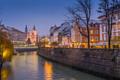 Ornate facade of Franciscan Church of the Annunciation and Ljubljanica River at dusk, Ljubljana, Slovenia, Europe