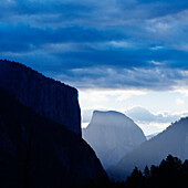 El Capitan and Half Dome in silhouette with evening clouds above. Yosemite National Park.