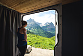 Woman looking out of van in Glacier National Park, Montana, USA