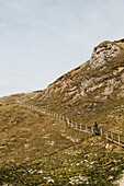 Sky over young woman walking up hillside staircase, Scotland, UK