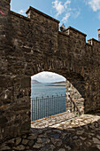 Fortified wall of Eilean Donan Castle against blue lake, Scotland, UK