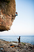 Two men rock climbing on seashore, Mallorca, Spain