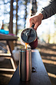 Person pouring coffee at picnic table, Harrison Hot Springs, British Columbia, Canada