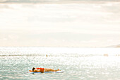 Woman lying on paddleboard, Ala Moana Beach Park in Honolulu, Oahu, Hawaii, USA