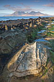 The Isle of Rum from Singing Sands on the Isle of Eigg, Small Isles, Inner Hebrides, Scottish Highlands, Scotland, United Kingdom, Europe