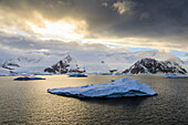 Sunrise, with atmospheric cloud and mist, mountains, glaciers and icebergs, Neko Harbour, Andvord Bay, Graham Land, Antarctica, Polar Regions